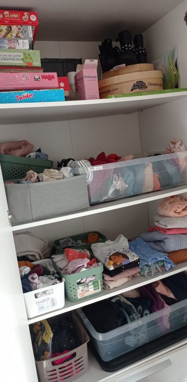 Étagères de dressing réorganisées avec bacs de rangement pour jeux, vêtements et affaires des enfants